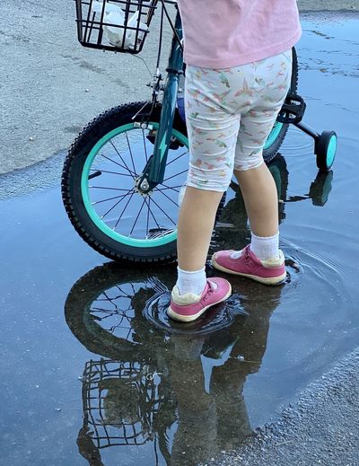 Low section of boy standing in puddle
