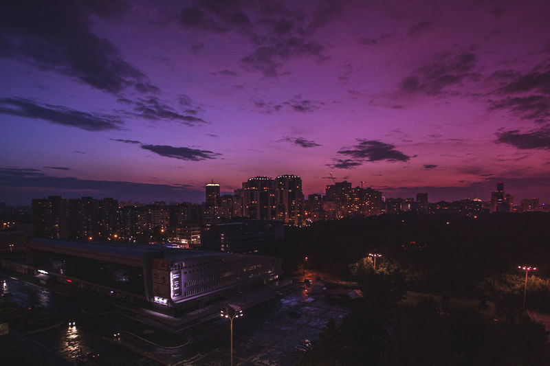 High angle view of buildings against purple sky at dusk in city