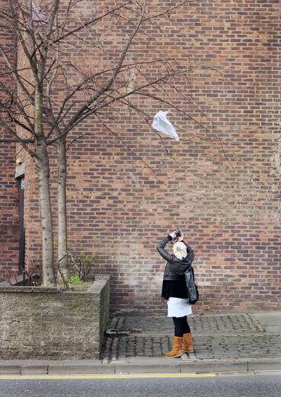 Woman capturing image of tree on camera 