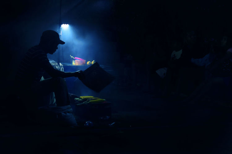 Man roasting sweetcorns at market