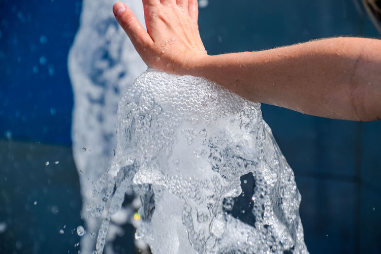 Cropped hand touching water in fountain