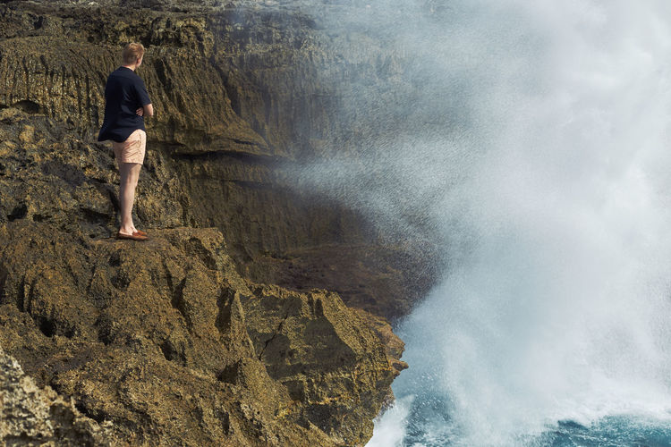 Full length of woman standing on rocks
