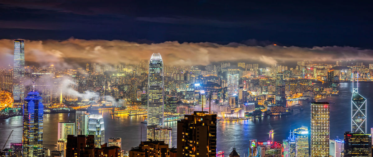 Illuminated cityscape against sky at night