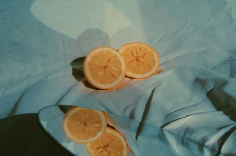 High angle view of orange slice on textile