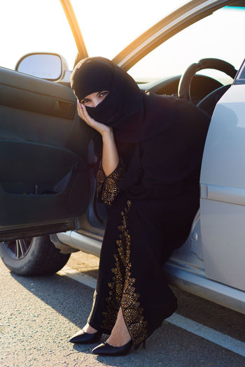 Portrait of woman in burka sitting in car