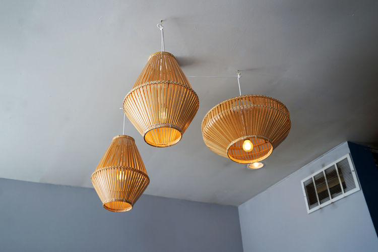 Low angle view of illuminated pendant lights hanging on ceiling