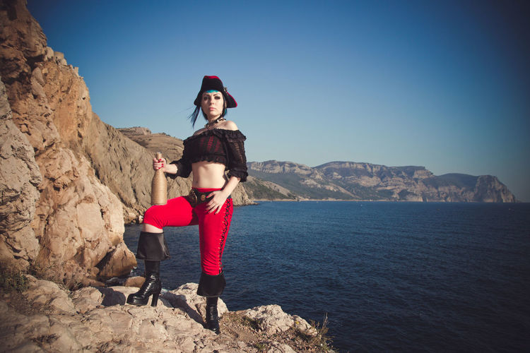 Portrait of a pirate woman at the beach. in anticipation of a pirate ship