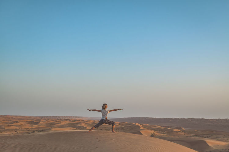 Woman practicing yoga in desert