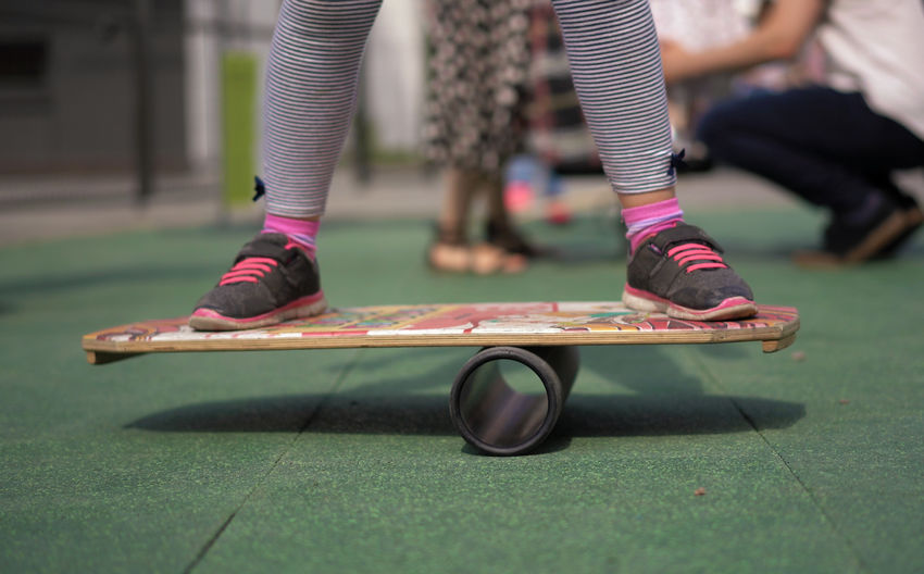 Low section of woman skateboarding in park