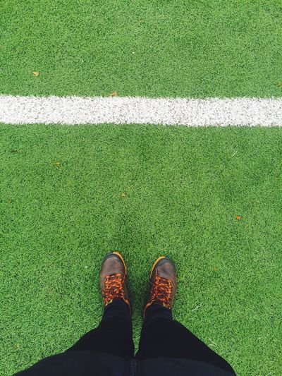 Low section of person standing on soccer field