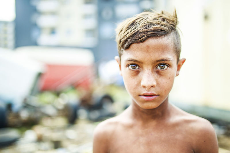 Portrait of shirtless boy standing outdoors