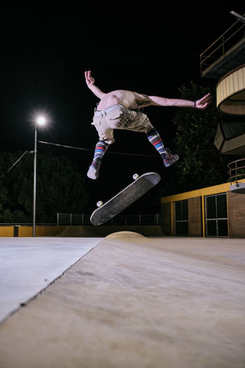 Young white man jumping on his skateboard