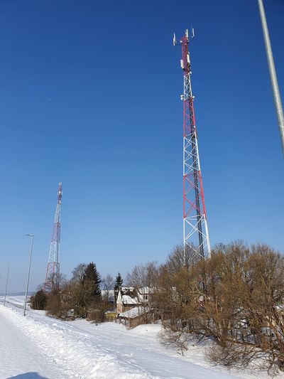 Low angle view of communications tower on field against clear sky