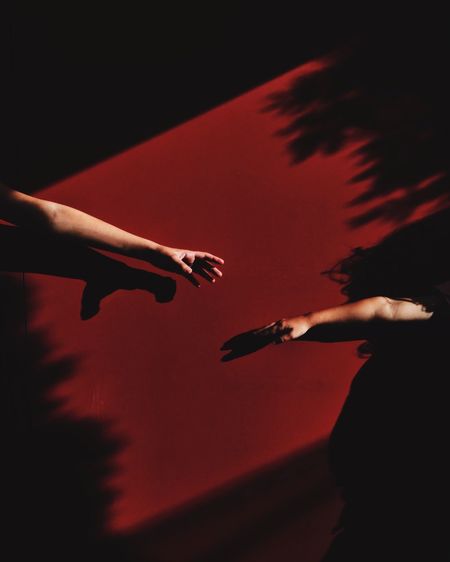 Low angle view of hands against red background