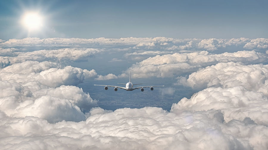 Airplane flying over cloudscape against sky