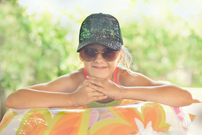 Girl in a cap and glasses on an inflatable ring