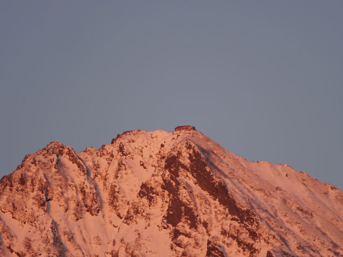 Low angle view of snowcapped mountains against clear sky