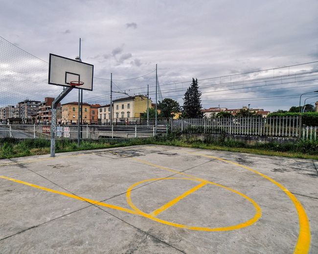 View of basketball court by road against sky