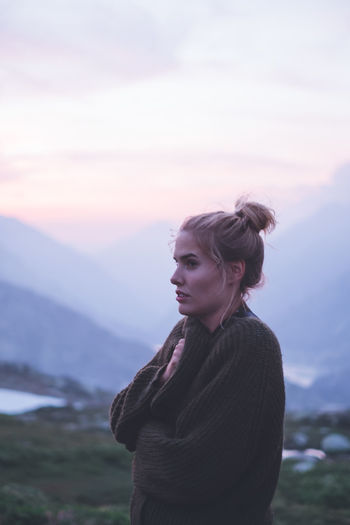 Woman wrapped in blanket standing on mountain