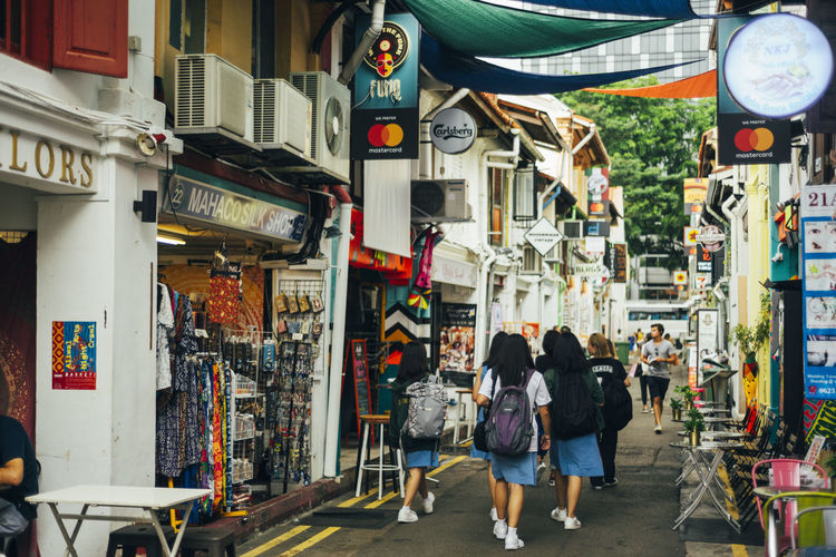 Rear view of people walking on street in singapore 