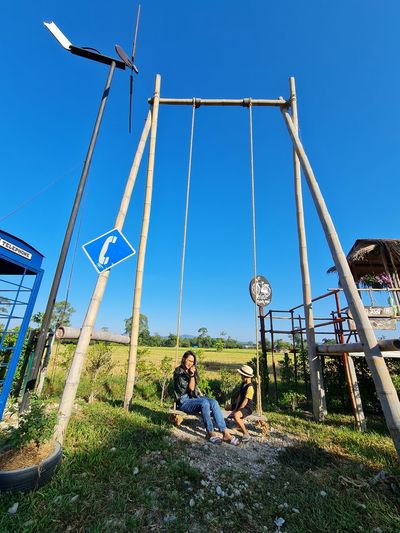 Young woman sitting on land against clear sky