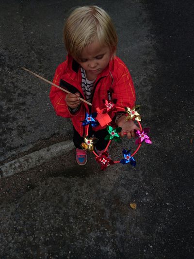 High angle view of girl holding pinwheel toy on footpath