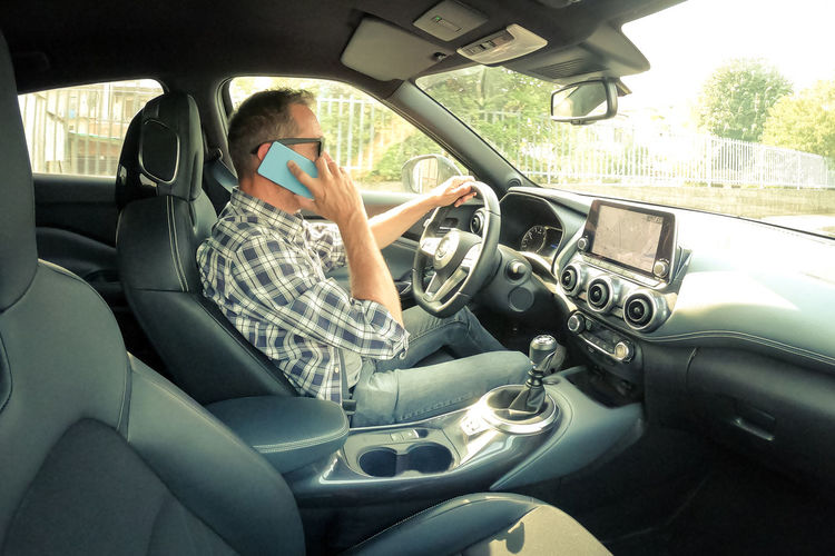 Man drive a car and use infotainment. driver male reading messages and make phone call while driving