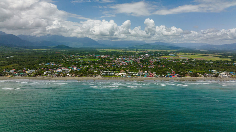 Sandy beach and ocean waves. coastline with hotels and tourists. sabang beach, baler, aurora