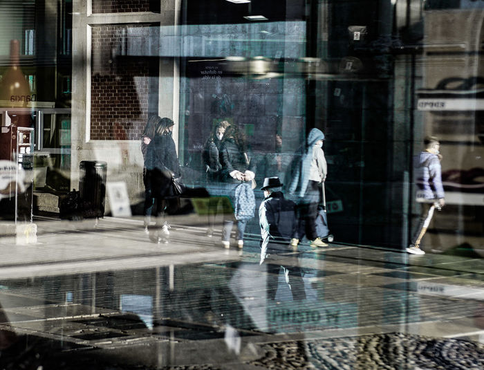 Digital composite image of people walking in glass building