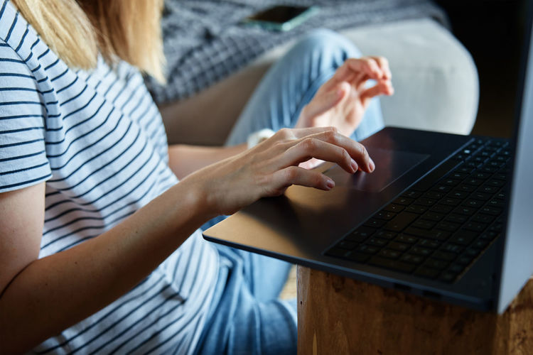 Midsection of woman using laptop