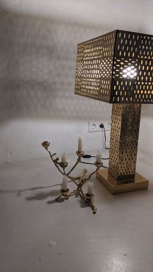 Close-up of illuminated lamp on table against wall at home