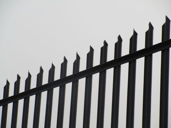 Low angle view of fence against clear sky