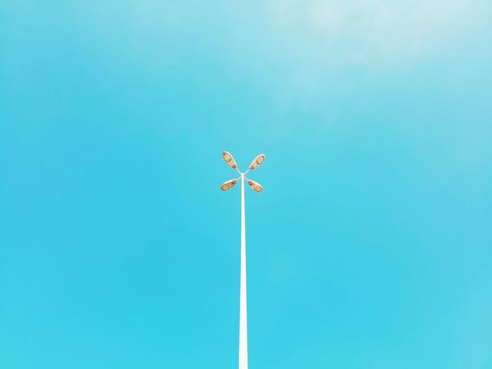 Low angle view of street lamp against clear blue sky