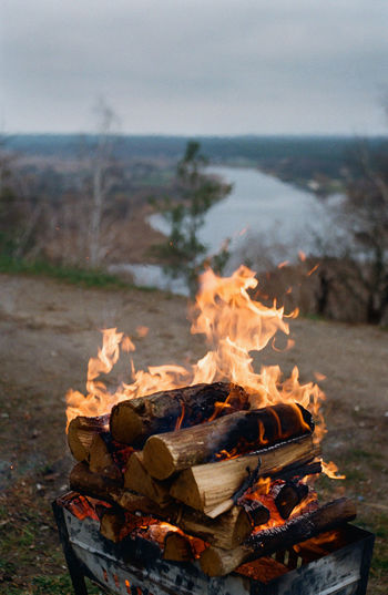 Bonfire on log against sky