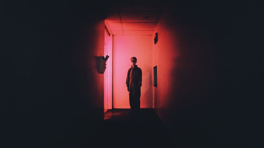 Young man standing in darkroom