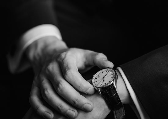 Closeup of businessman checking time on watch