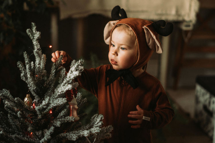 Boy looking at christmas tree at home