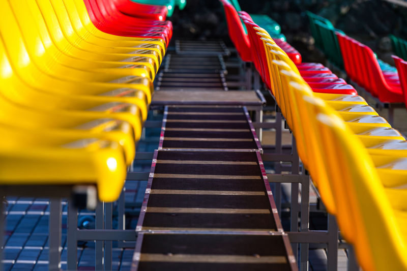 A fragment of the grandstand of an sports stadium with multi-colored seats