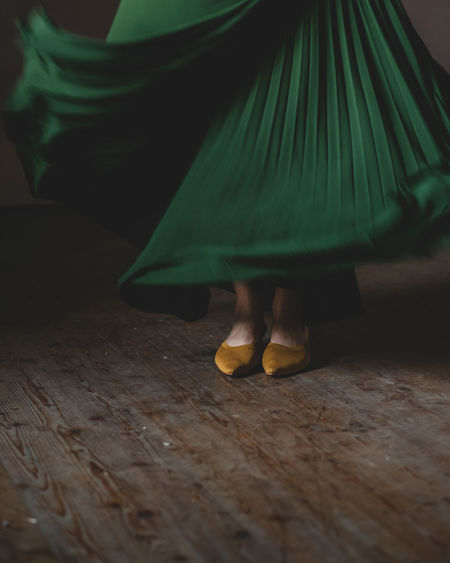 Low section of woman with green twirling skirt