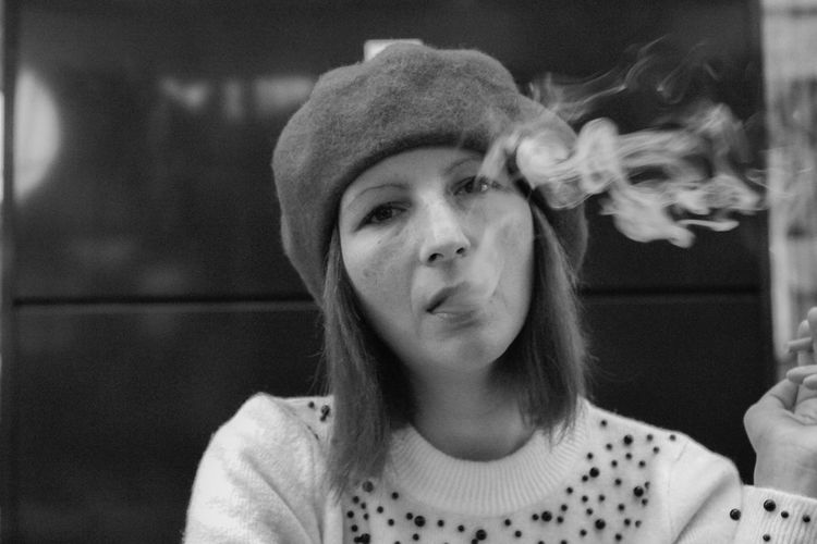 Close-up portrait of woman exhaling smoke