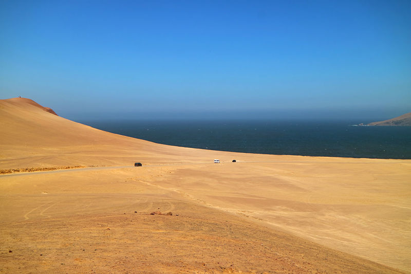 The vast sand dunes of paracas national reserve with pacific ocean in the backdrop, ica region, peru