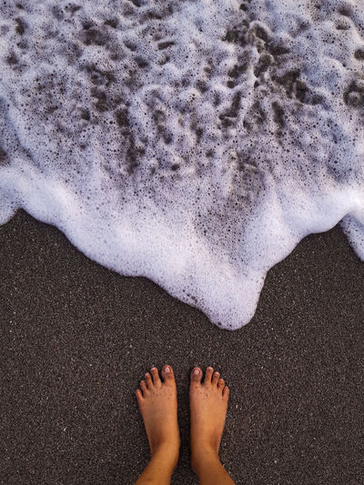 Barefoot on  beach sand and waves