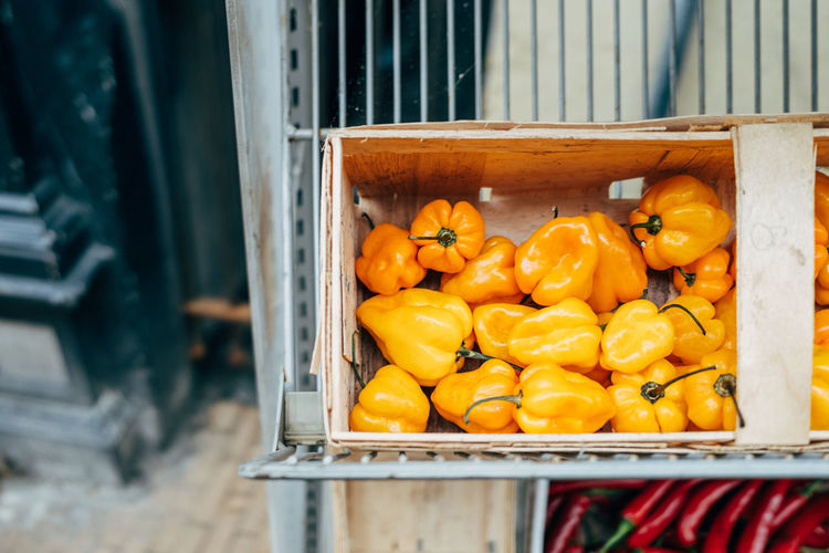 Yellow pepper for sale in wooden box on market stall