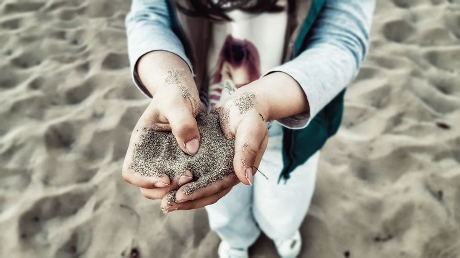 Girl holding sand at beach