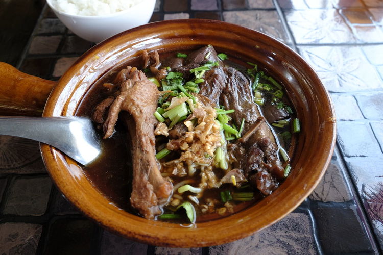 Bowl of rice and hot meat stew in clay pot