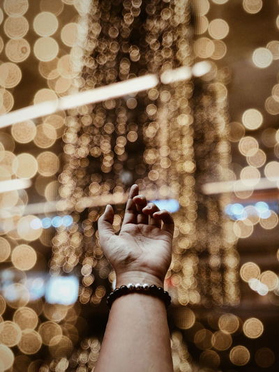 Close-up of hand holding illuminated christmas lights