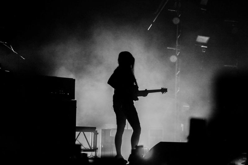 Silhouette person playing guitar at music concert