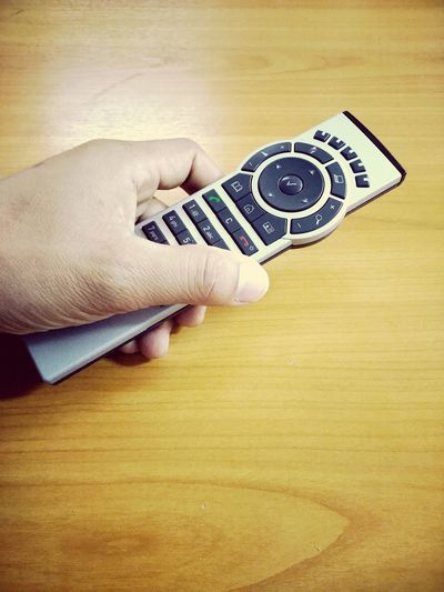 Close-up of hand holding camera on table
