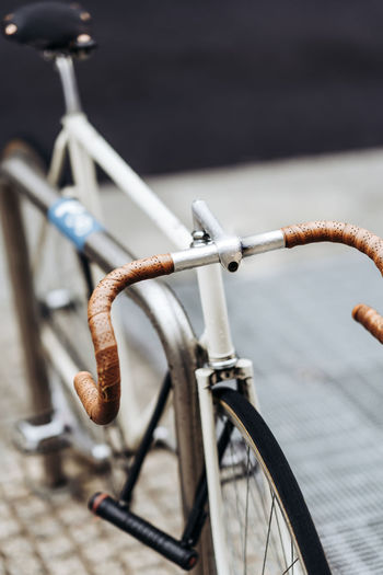 Close-up of bicycle on railing by street