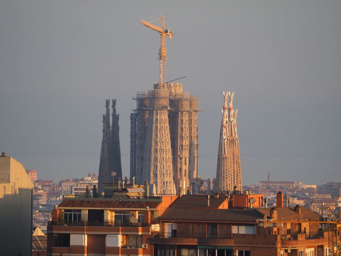 Sagrada familia towers in city against sky